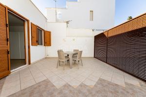a dining room with a table and chairs on a patio at Giorni Salentini in Torre Lapillo