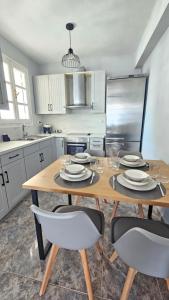 a kitchen with a wooden table with chairs and a refrigerator at Κάρτ Ποστάλ Τρίκερι- Carte Postale Trikeri in Trikeri +4 photos