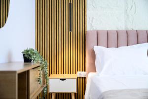 a bedroom with a bed and a table with a night stand at Korina Suites in Perea +12 photos