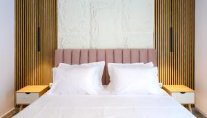a bedroom with a bed with white sheets and pillows at Korina Suites in Perea