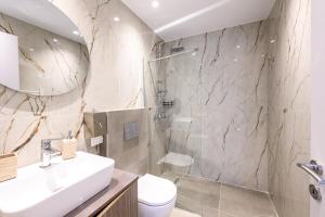 a bathroom with a shower and a sink and a toilet at Korina Suites in Perea
