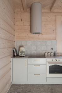 a kitchen with white counters and a stove top oven at Ziębowe Ranczo in Chochołów