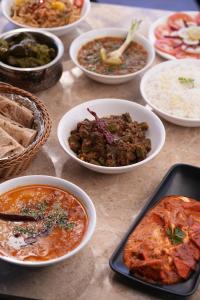 a table topped with bowls of different types of food at Nature's Glory Resort in Panchgani
