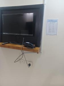 a flat screen tv sitting on a wooden shelf at فندق علي عايض الدوسري in Abu Arish