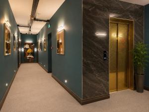 a hallway with blue walls and a door with a plant at Gori Palace - Modern Apartments in City Centre in Gori