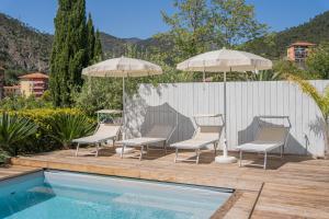 a group of chairs and umbrellas next to a pool at Ulivo, Relax a due passi dal mare in San Lazzaro