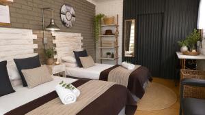 a bedroom with two beds and a clock on the wall at De Haven Oost in Rayton +4 photos