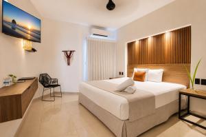 a bedroom with a large bed and a desk at Aruma Suites in Playa del Carmen +43 photos