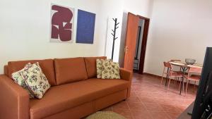 a living room with a brown couch and a table at Habita Avenida 9 Abril in Estremoz