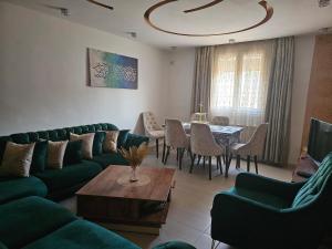 a living room with a green couch and a table at Ayem house in Souidania