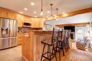 a kitchen with wooden cabinets and a island with bar stools at Woods 21 Townhome in Copper Mountain