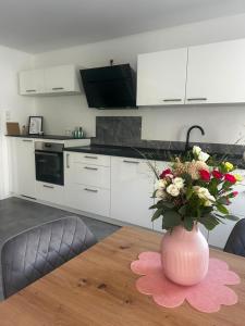 a vase with flowers on a table in a kitchen at Moselglück in Pölich