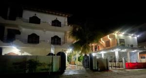 a building with a palm tree in front of it at night at Athena Guest House in Trincomalee +9 photos