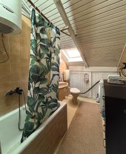 a bathroom with a bath tub and a toilet at The Vibe Spot in Podgorica +17 photos