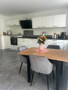 a kitchen with a wooden table with a vase of flowers on it at Moselglück in Pölich