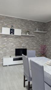a living room with a television and a table with chairs at Casa Enza in Forio d'Ischia