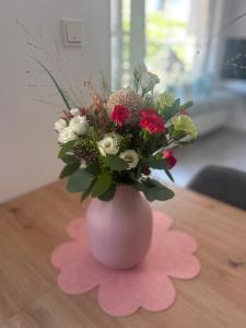 a pink vase filled with flowers on a table at Moselglück in Pölich +35 photos