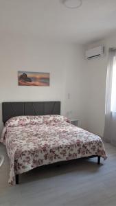 a bedroom with a bed with a floral bedspread at Casa Enza in Forio d'Ischia