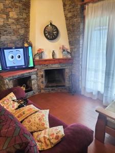 a living room with a tv and a fireplace at Cal Rafalet in Ger