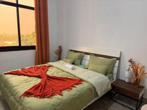 a bedroom with a bed with an orange blanket on it at Premium apartment with balcony in La Gombe in Kinshasa