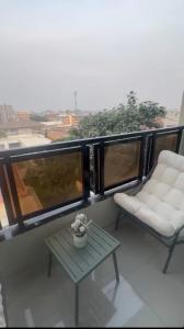 a balcony with two chairs and a table with a view at Premium apartment with balcony in La Gombe in Kinshasa