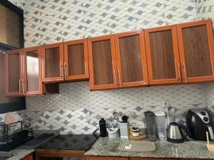 a kitchen with wooden cabinets and a counter top at Premium apartment with balcony in La Gombe in Kinshasa
