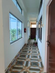 a hallway with a tiled floor and a door at PINES and PETALS in Jorhat