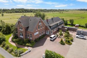 an aerial view of a large house with cars parked in a parking lot at Hotel Norden Norddeich in Norddeich