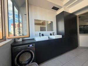 a bathroom with a washing machine and two sinks at Englishman Hostel Shkoder Backpackers Instant Sleep in Shkodër