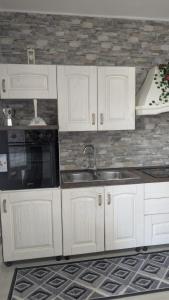 a kitchen with white cabinets and a sink at Casa Enza in Forio d'Ischia