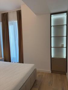 a bedroom with a bed and a book shelf at Oasis-First Estates Pipera in Voluntari
