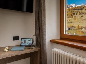 a room with a window with a view of a mountain at Hotel Zanella in Peio Fonti