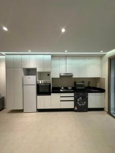 a large kitchen with white cabinets and appliances at Igar Azougagh Immeuble DII in Al Hoceïma