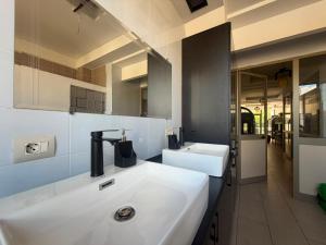 a bathroom with two white sinks and a mirror at Englishman Hostel Shkoder Backpackers Instant Sleep in Shkodër