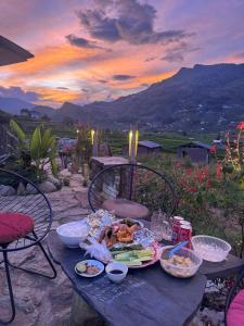 a picnic table with food on it with a sunset at Stilla Home in Tả Van