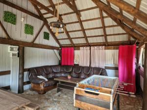 a living room with a leather couch and a table at Osada Modrzewiowe Wzgórze Bieszczady in Ustrzyki Dolne +48 photos
