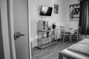 a room with a television and a table with a chair at Bockwirt in Schladming