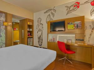 a bedroom with a bed and a desk with a red chair at Novotel Bengaluru Outer Ring Road in Bangalore +125 photos