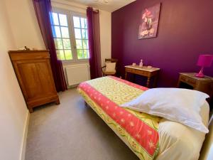 a bedroom with a bed and a table and a window at La Rousselie in Montagrier