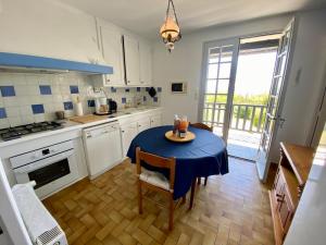 a kitchen with a table with a blue table cloth on it at La Rousselie in Montagrier