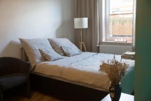 a bedroom with a bed with a chair and a window at Nie Samym Chlebem in Poborszów