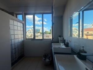 a bathroom with two sinks and a large window at Englishman Hostel Shkoder Backpackers Instant Sleep in Shkodër +17 photos