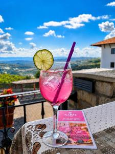 a drink in a glass sitting on a table with a book at Sevastokrator Relax & Congress in Arbanasi
