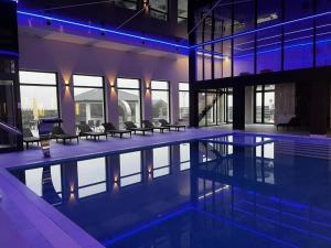 a swimming pool in a building with blue lights at Holiday Home Resort & Spa in Jarosławiec