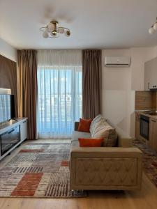 a living room with a couch and a television at Oasis-First Estates Pipera in Voluntari