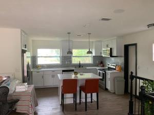 a kitchen with white cabinets and a table and chairs at 2Bed 2Bath Lake Front Jewel in Lake Mary