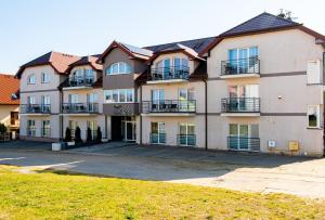 a large apartment building with balconies and a yard at Holiday Home Resort & Spa in Jarosławiec