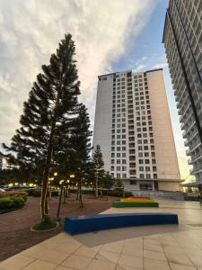 a large building with a tree in front of it at SMDC Wind Residences Condo Unit by Bil & J's in Kaybagal