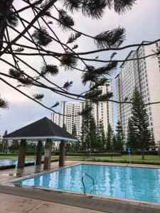 a swimming pool in front of a large building at SMDC Wind Residences Condo Unit by Bil & J's in Kaybagal