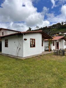 a white house with a picnic table in the yard at Villa Belén in Guarne